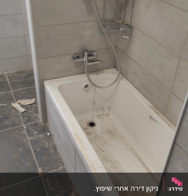 אמבטיה מלוכלכת עם שאריות לכלוך על הרצפה